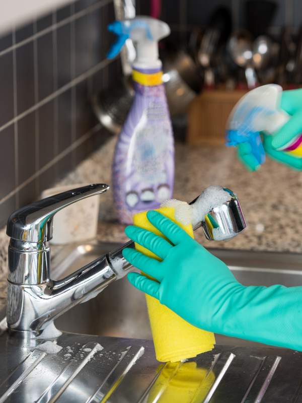 house cleaner scrubbing kitchen sink