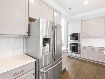 residential home kitchen with white cabinets and stainless steel fridge